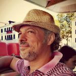 homme portant un chapeau en terrasse de bistrot