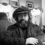 le musicien pablo cueco photographié en noir et blanc par Photo Milomir Kovacevic à la table d'un bistrot